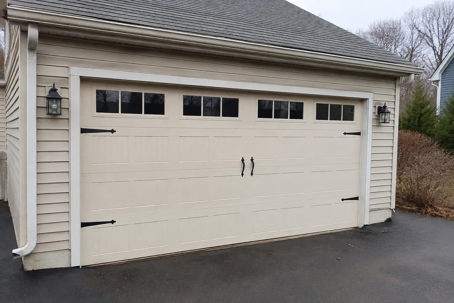 Cream carriage-house-style garage door with dark decorative hardware. — Carriage-House Garage Door Installation, Springwater
