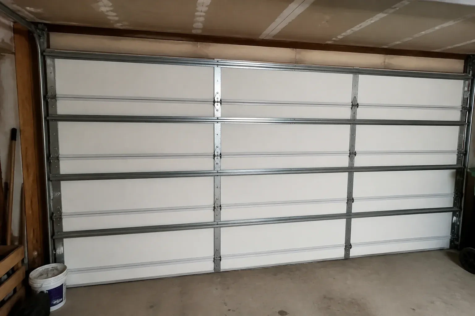 Interior of a closed sectional door with horizontal metal reinforcement struts. — Wind-Rated Garage Door Replacement, Springwater
